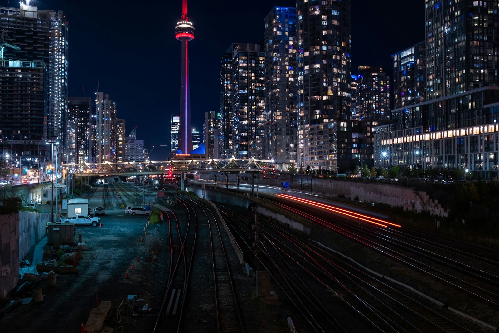 Toronto skyline and the CN Tower at night, seen across rail yards